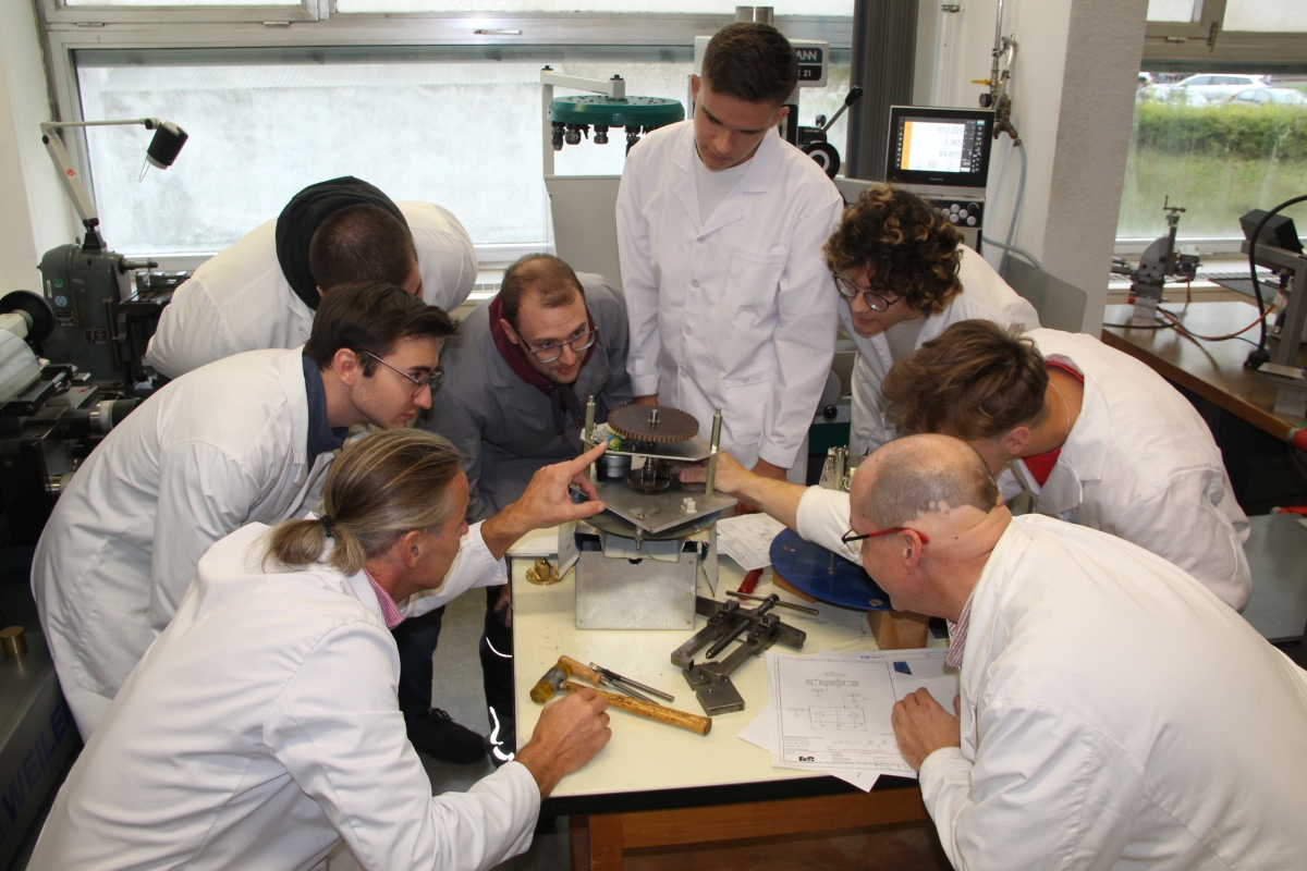 Uhrmacherschüler und -lehrer tüfteln eifrig am neuen Uhrwerk der Schwenninger Messeuhr. Foto: Mareike Kratt